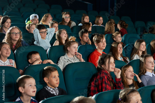 Foto Group of stylish teenagers and children expressing facial emotions in movie theatre