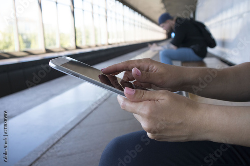 girl or female hands with white tablet in subway