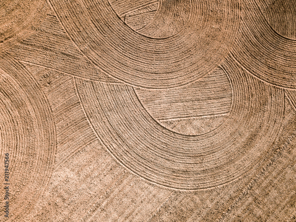 Naklejka premium Spring arable land. Field and beautiful patterns from the tractor. View from above. 