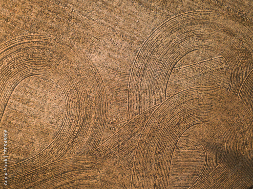 Naklejka premium Spring arable land. Field and beautiful patterns from the tractor. View from above. 