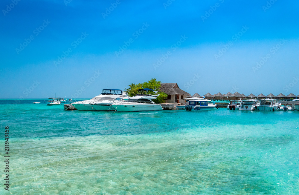 A pier in a tropical island. Yachts in a turquoise lagoon. Maldives holiday