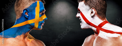 Soccer or football fan with bodyart on face with agression - flags of Sverige, Sweden vs England. Sport Concept with copyspace.