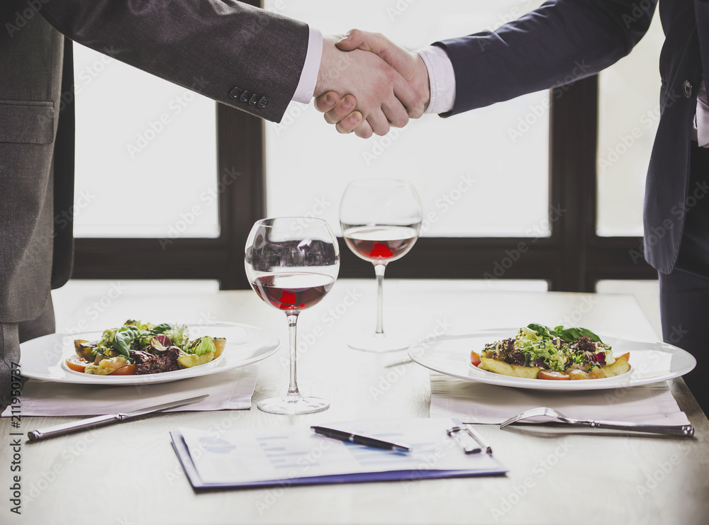 Close up. Businessmen Shaking Hands in Restaurant. Close up. Businessmen Shaking Hands in Restaurant.