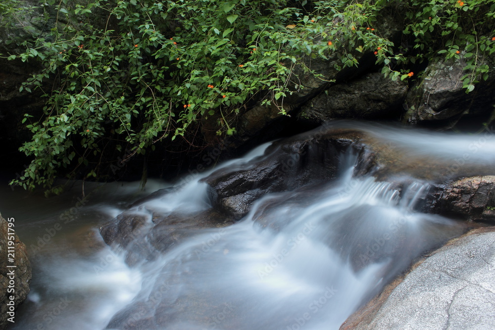 Tropical yoga session by beautiful Sticky Waterfall close to Chiang Mai in north Thailand.