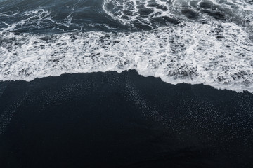 Poster Zwart Schuimende golven op zwart lavastrand  © glass_frog