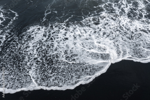 white ocean foam on black sand volcanic texture © glass_frog