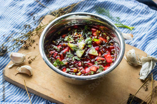 Cold soup Chrianteli with sour cherry or blackberry juice. Georgian traditional summer food with garlic, green herbs, cucumbers. Raw vegan vegetarian healthy food. photo