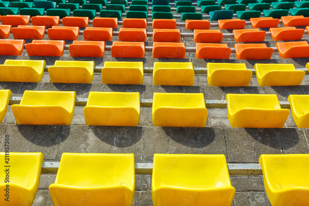 Fototapeta premium multi-colored rows of plastic seats in the stadium