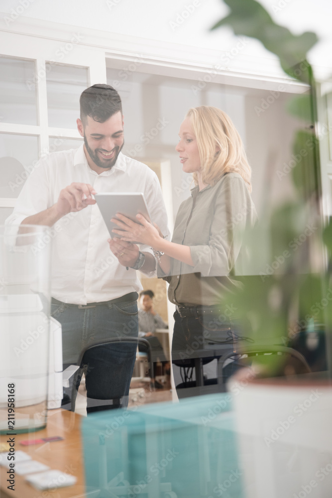 Man and woman smiling as she holds a pc tablet Man and woman smiling as she holds a pc tablet