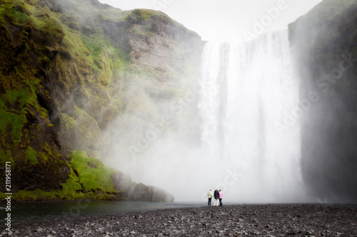 People appear small in front of a 60m high waterfall photo