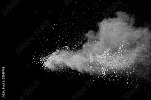 Bizarre forms of white powder explosion cloud against dark background. Launched white dust particle splash on black background.