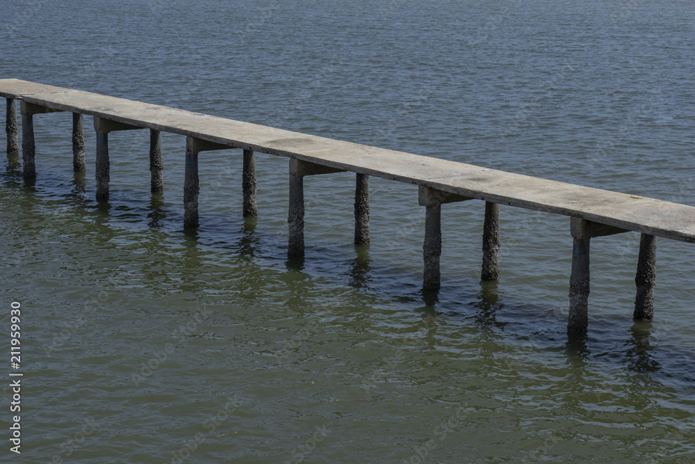 Long old concrete bridge over the sea with some shellfish in pile Long old concrete bridge over the sea with some shellfish in pile