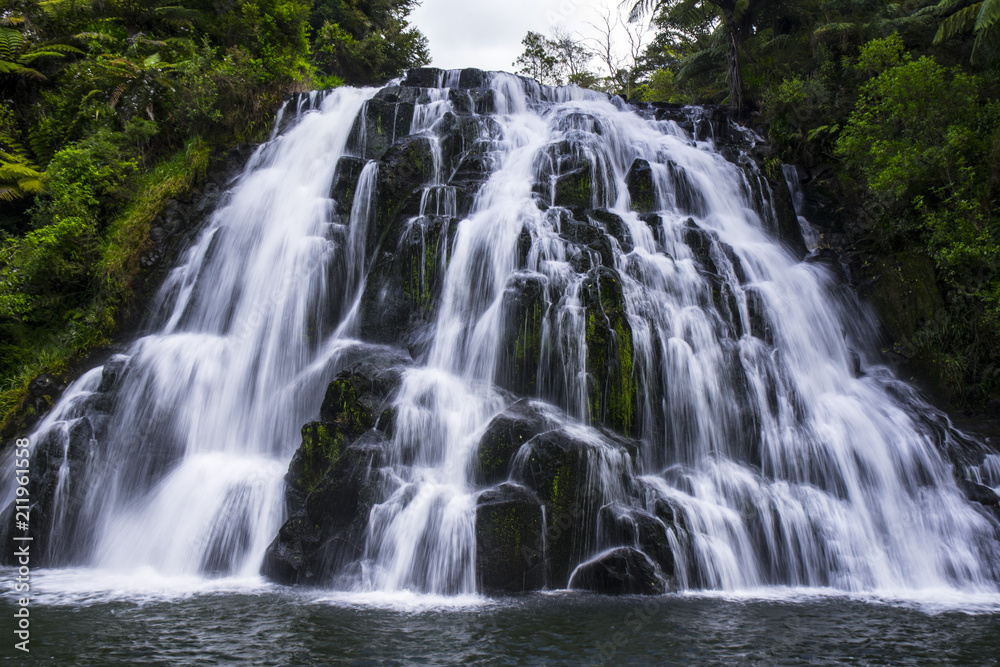 Travel/Exploring beauty of New Zealand. Owharoa Falls, Waihi, favourite/popular nature attraction in North Island. Long exposure falling water. Green, outdoor background. Travel/Exploring beauty of New Zealand. Owharoa Falls, Waihi, favourite/popular nature attraction in North Island. Long exposure falling water. Green, outdoor background.
