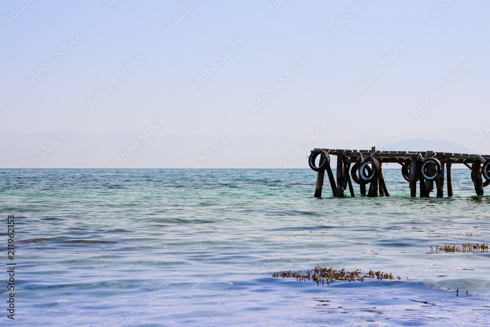Fototapeta premium beautiful marina on nature shore of the sea background. Old wooden pier on sea coastline ,on clear sky background. Copy space