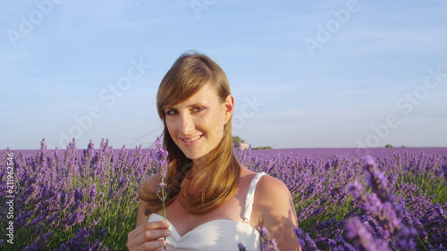 Fototapeta Naklejka Na Ścianę i Meble -  SLOW MOTION: Portrait of young woman in endless lavender field