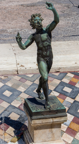 Italy, Pompeii - 13/06/2018: Bronze faun (satyr) statue in Pompeii, Italy. Antique culture concept. Italian landmark. Archeological digs. Pompeii ruins. Ancient roman sculpture. 