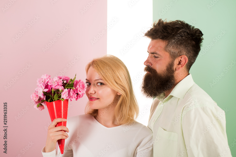 Woman enjoy fragrance bouquet flowers. Couple in love happy celebrate anniversary. Man with beard takes care about girlfriend happiness. Lady likes flower husband gifted her. Flowers delivery concept Woman enjoy fragrance bouquet flowers. Couple in love happy celebrate anniversary. Man with beard takes care about girlfriend happiness. Lady likes flower husband gifted her. Flowers delivery concept