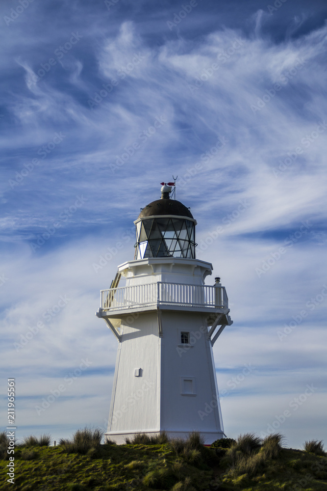 Travel New Zealand. Scenic view of white lighthouse on coast, ocean, outdoor background. Popular tourist attraction, Waipapa Point Lighthouse located at Southland, South Island. Travel concept.