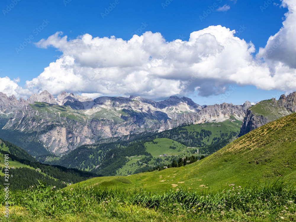 Picturesque July Alpine view from the Sella Pass in the Dolomites with big cumulus clouds, in South Tyrol, Italy
