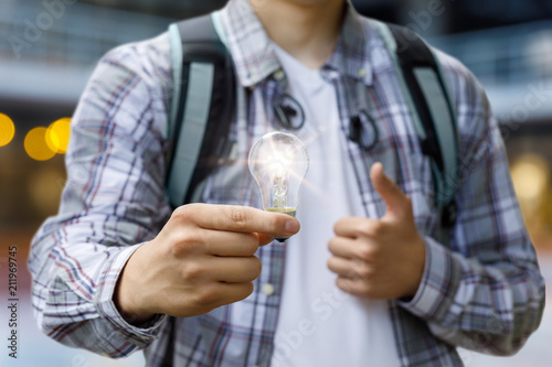 A student holding a burning light bulb.