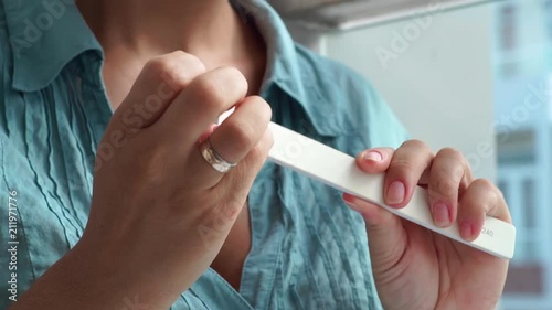 Woman filing nail with nail file while home manicure. Home manicure and nail care. Woman doing yourself manicure close up.