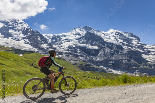 nice and ever young senior woman riding her e-mountainbike below the Eiger Northface near Grindelwald and Wengen, Jungfrauregion, Switzerland