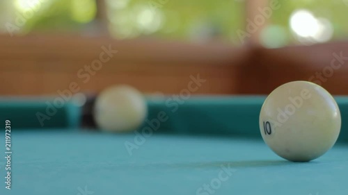 The player pushes the ball from the billiard to the pocket photo