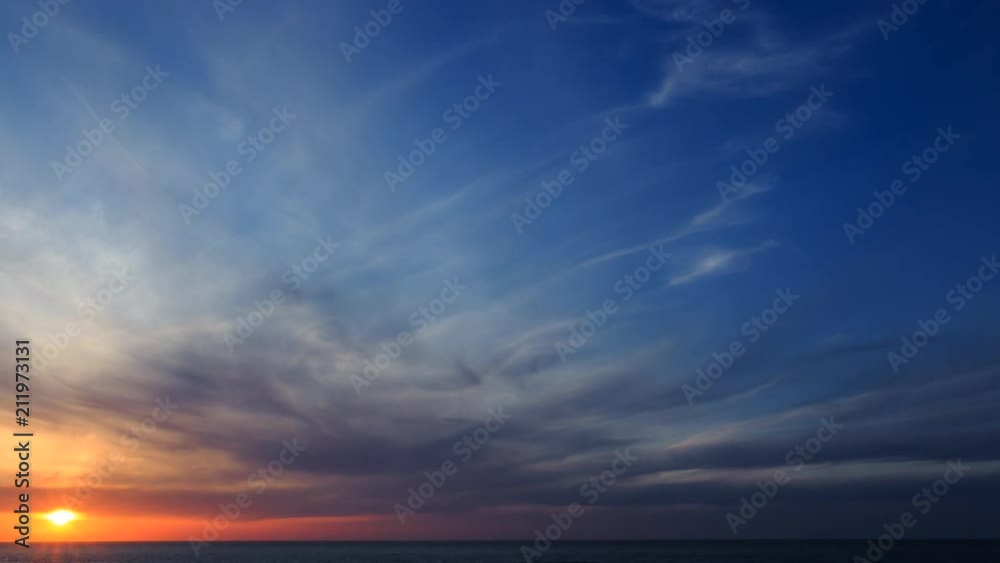 Time lapse of beautiful sunset over the ocean on the beach of Normandy, France. Ocean waves coming up on the shore. Picturesque cloudy sky. Calmness, meditation and relax concept