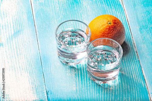 two glasses of vodka on a wooden table painted in blue