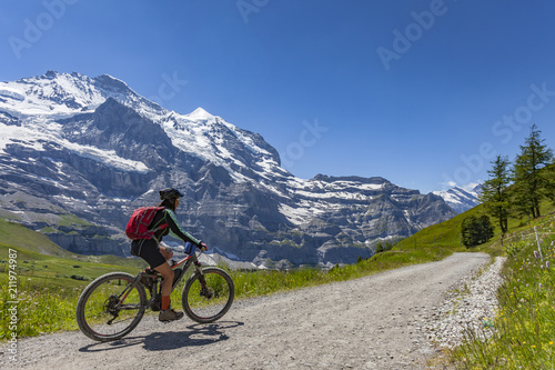 nice senior woman, riding her e-mountainbike on the Lauberhorn downhill from Kleine Scheidegg to Wengen and Lauterbrunnen,Jungfrauregion,Switzerland © Uwe