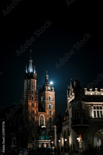 Old city center view St. Mary's Basilica, Square market in Krakow. Night Krakow. Moon over the church. Ancient building.