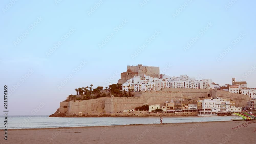 Teal and orange mood of Old town on the sea. The castle of Peniscola, located on Costa del Azahar in the Castellon province of Spain. This popular tourist destination is located on a rocky headland Teal and orange mood of Old town on the sea. The castle of Peniscola, located on Costa del Azahar in the Castellon province of Spain. This popular tourist destination is located on a rocky headland