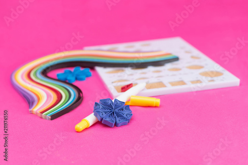 A flower made of paper.Quiling art. In the background equipment for work in quilling technique. photo