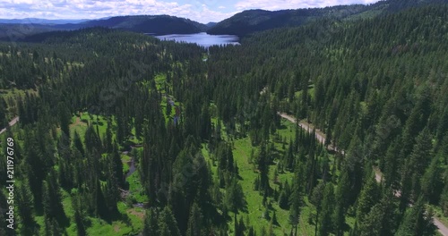 Aerial Flyover of Creek Flowing Towards Mountain Lake