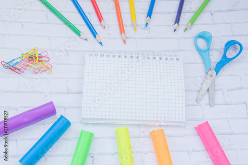 Color school supplies. Color pencils, markers, tassels, rubber, notebook, clips, multicolor plasticine, scissors photo