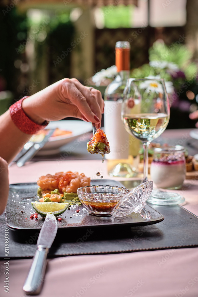 Fresh tartar with salmon, avocado, red caviar on black plate Fresh tartar with salmon, avocado, red caviar on black plate