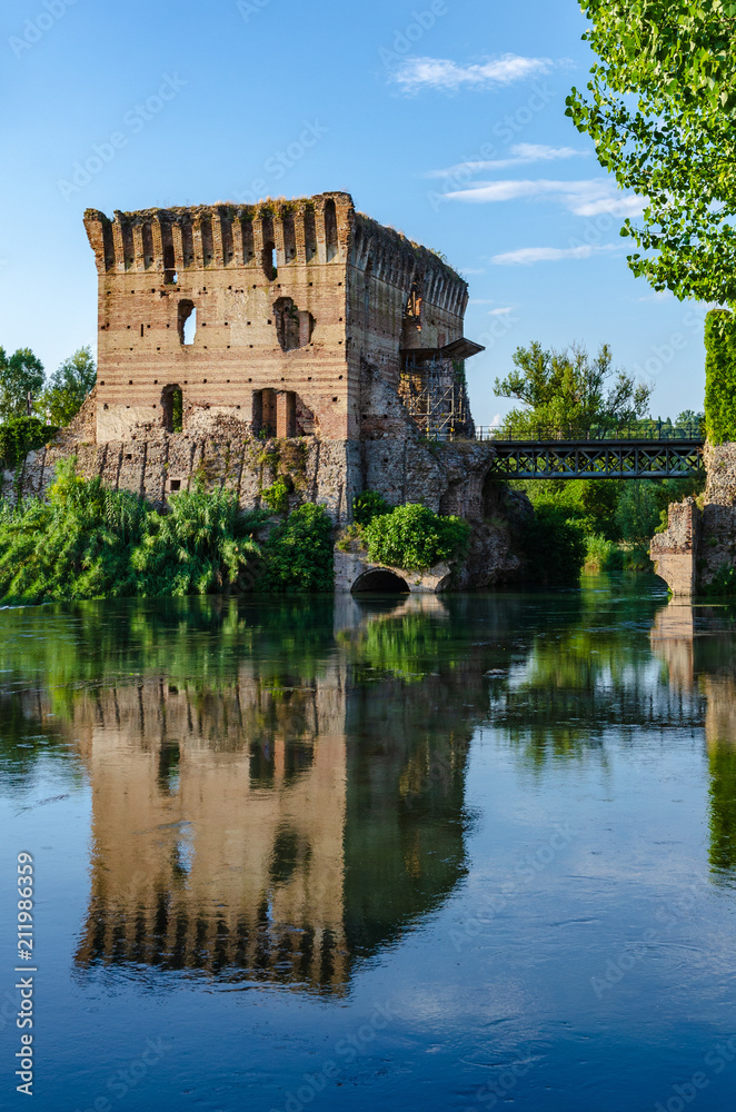 Visconti bridge of Valeggio sul Mincio at Borghetto with reflections in Mincio river, Italy