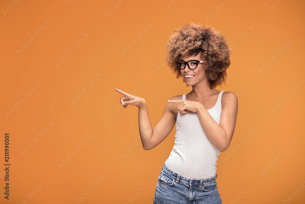 Smiling beautiful african american woman on yellow background.