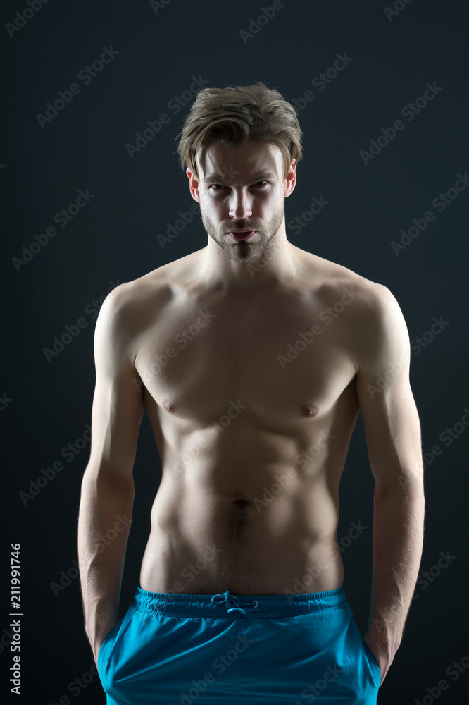 Fototapeta premium Sport or fitness and bodycare concept. Man with six pack and ab muscles. Sportsman with sexy torso and chest. Training and workout activity in gym. Athlete with fit body in shorts