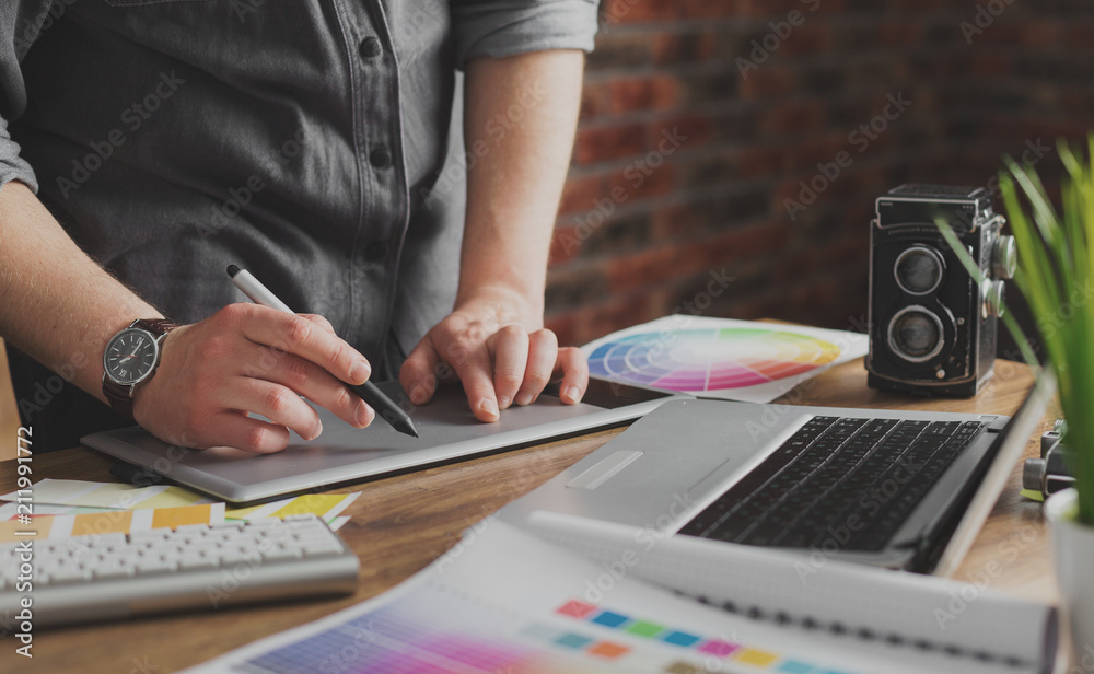 Young creative artist of web design in hat with graphic tablet in modern loft office Young creative artist of web design in hat with graphic tablet in modern loft office