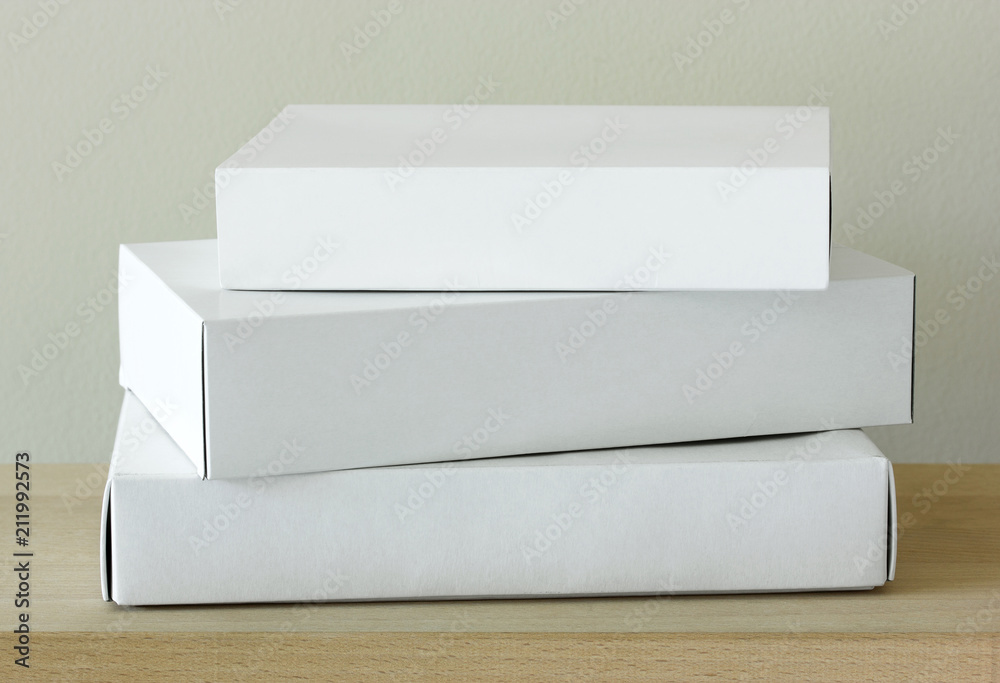 Stack of white cardboard package box mockup on wooden table Stack of white cardboard package box mockup on wooden table