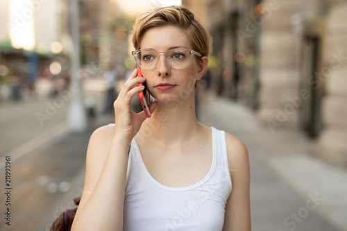 Woman in city walking talking on cell phone