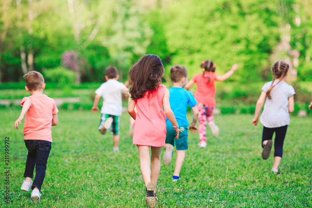 Many different kids, boys and girls running in the park on sunny summer day in casual clothes Many different kids, boys and girls running in the park on sunny summer day in casual clothes