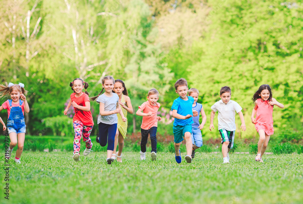 Fototapeta premium Many different kids, boys and girls running in the park on sunny summer day in casual clothes