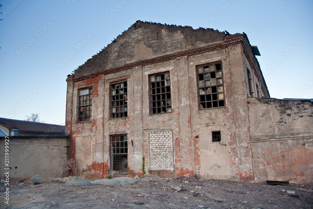Abandoned ruined industrial building waiting for demolition. Territory of abandoned industrial area Abandoned ruined industrial building waiting for demolition. Territory of abandoned industrial area