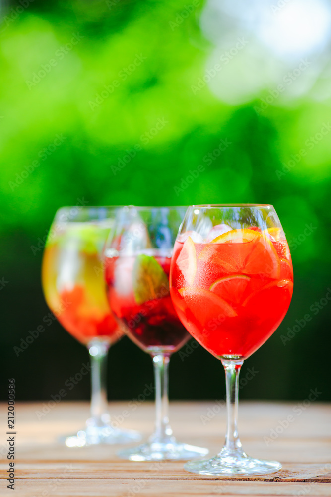 Summer cocktail. Fruit cocktail on green background. Citrus fruits, berries, strawberries, blueberries, mint, ice. Summer cocktail. Fruit cocktail on green background. Citrus fruits, berries, strawberries, blueberries, mint, ice.
