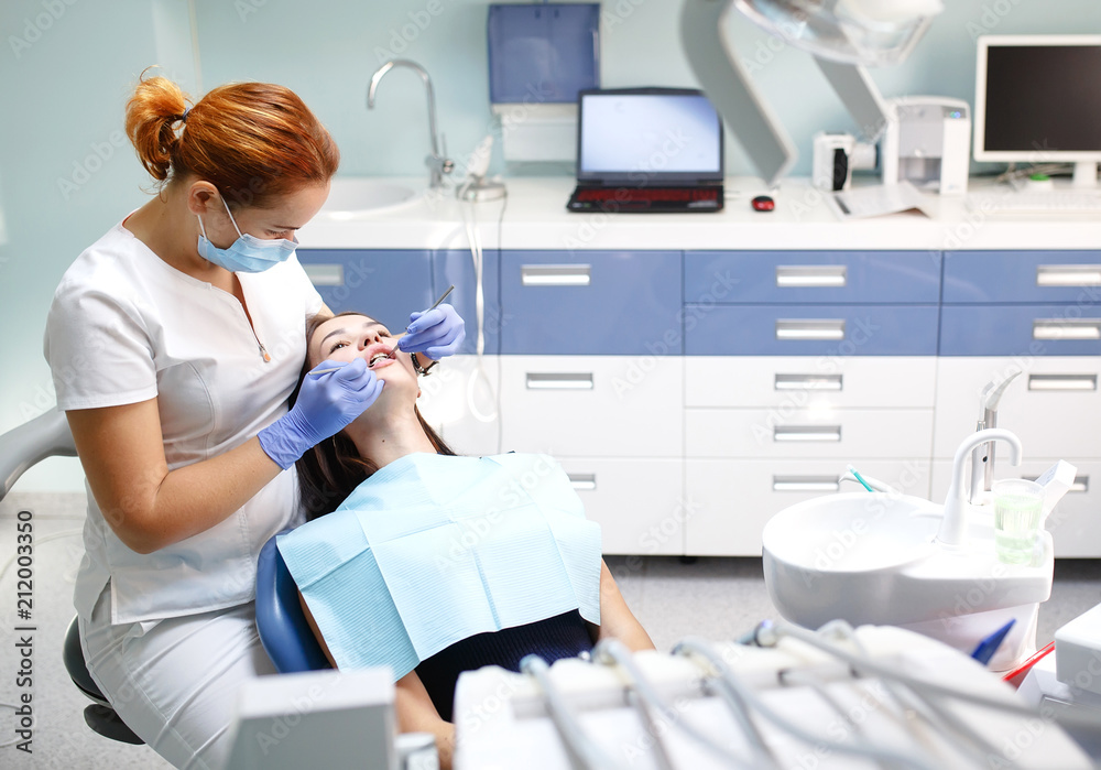 Fototapeta premium female dentist checking patient girl teeth