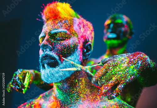 Concept. A bearded man in Barbershop. A stylish bearded man is trimmed  in Barber Shop. The man is decorated in ultraviolet powder.