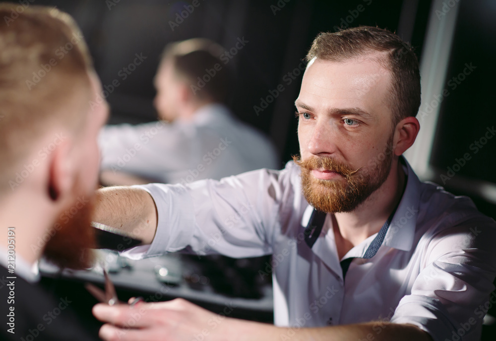 Fototapeta premium Confident man visiting hairstylist in barber shop.