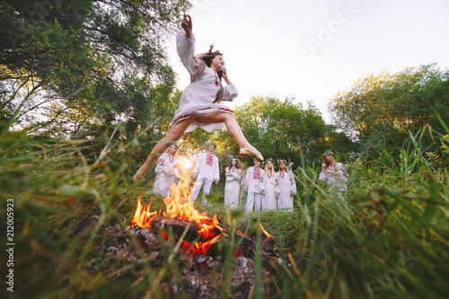 Midsummer. Girl jumping over the fire.